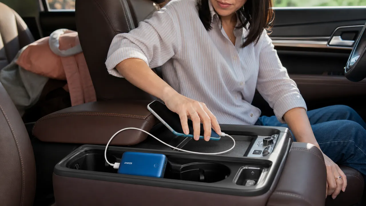 Anker PowerCore 10K portable charger connected to a smartphone on a car console organizer tray